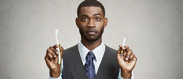 Man holding a toothbrush and cigarette