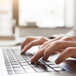 Hands at a computer keyboard