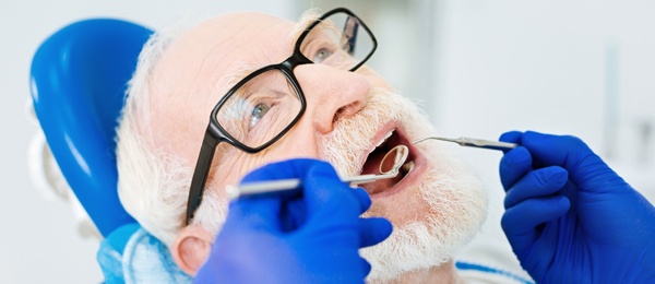 Elderly man getting his mouth examined