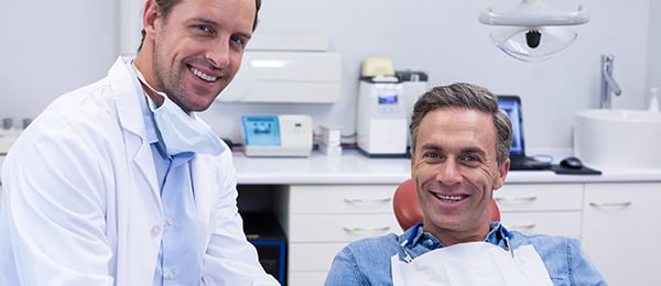 Smiling dentist with senior smiling patient