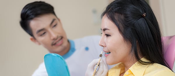 Dentist and patient viewing the esthetics of a dental implant