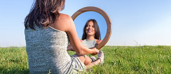 Photo of woman looking in mirror