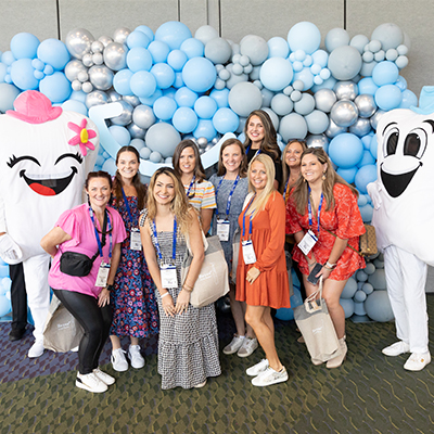 Happy SmileCon attendees posing with stuffed teeth
