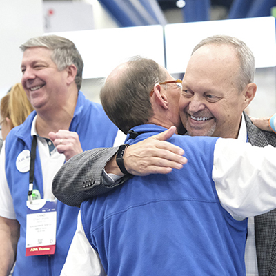 SmileCon attendees hugging in Dental Central