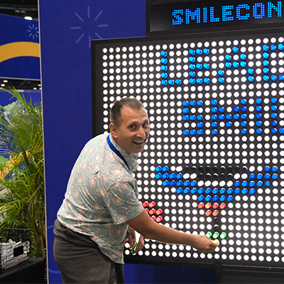 SmileCon attendee at giant light brite board