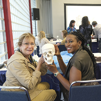 Smiling Attendees at SmileCon 2022 holding a skull